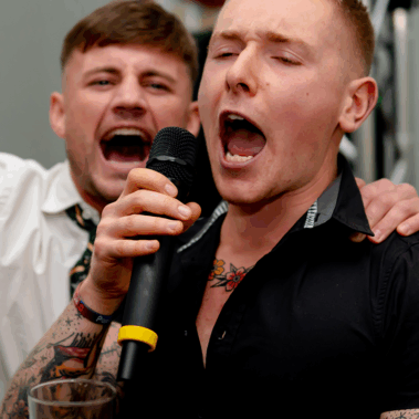 man scremaing down mic at karaoke