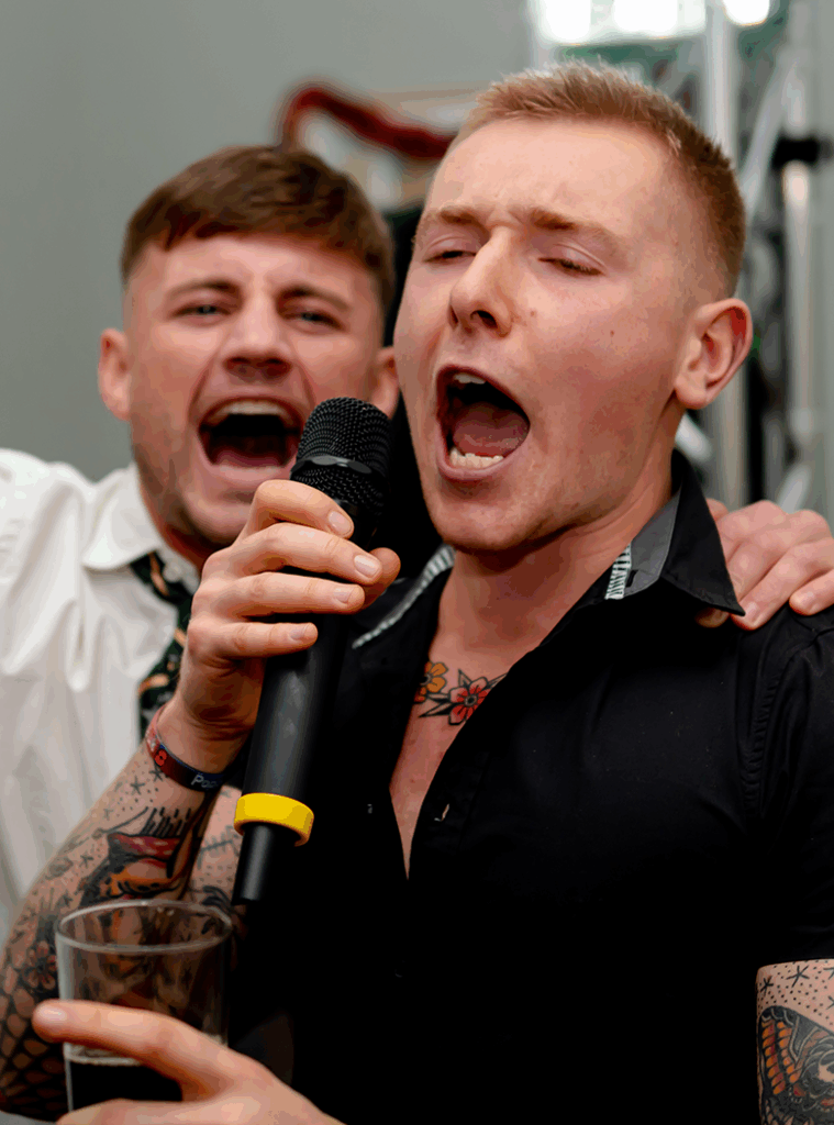 man scremaing down mic at karaoke